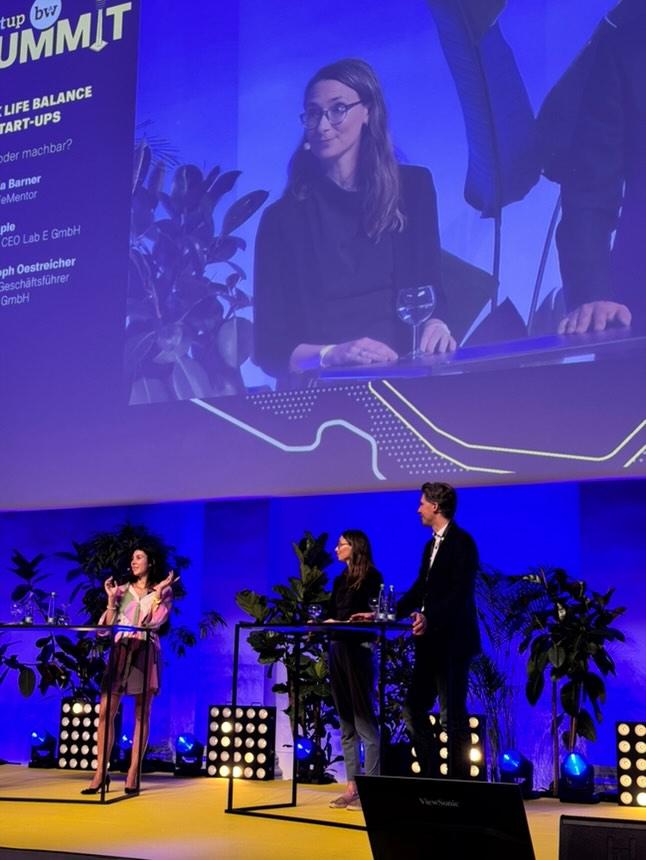 Carola Epple auf der Bühne beim Startup BW Summit, im Hintergrund die Projektion des Panels